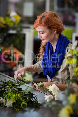 Female florist trimming flower stem