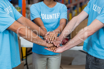 Mid section of volunteers putting hands together
