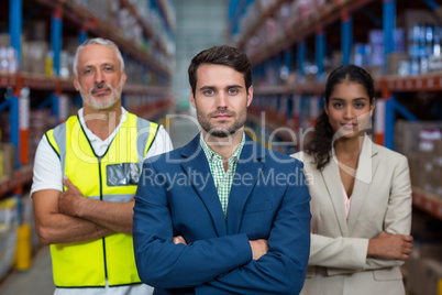 Portrait of warehouse team standing with arms crossed