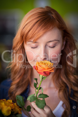 Female florist smelling a rose flower