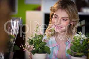 Happy female florist looking at flower pot