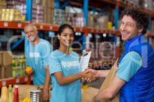 Portrait of volunteers shaking hands while working