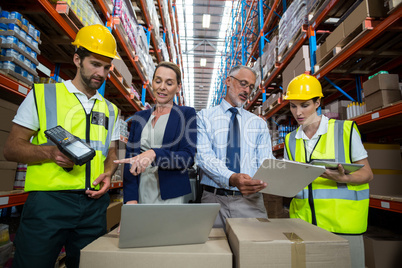Warehouse manager and client interacting with co-workers