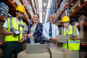 Warehouse manager and client interacting with co-workers