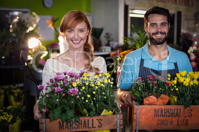 Portrait of couple holding crate of flower bouquet