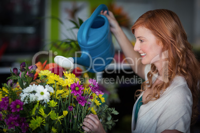 Female florist watering flowers