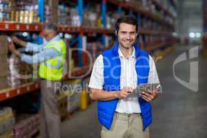 Warehouse worker holding digital tablet