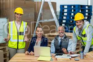 Warehouse managers and workers smiling in warehouse