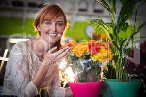 Portrait of female florist touching rose flowers