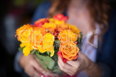 Female florist holding bunch of flowers