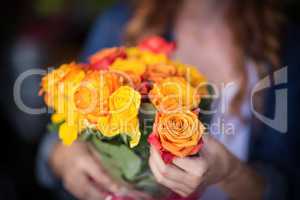 Female florist holding bunch of flowers