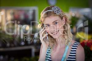 Female florist talking on mobile phone