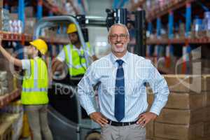 Warehouse manager standing with hands on hips