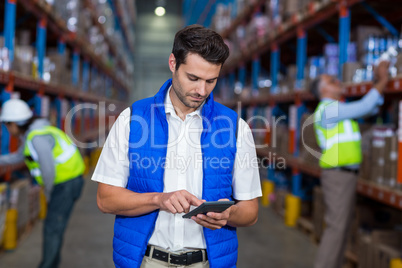 Warehouse worker using calculator