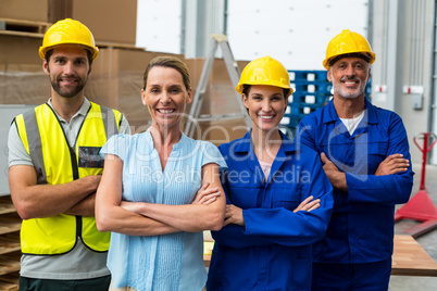 Portrait of warehouse manager and worker standing together with arms crossed