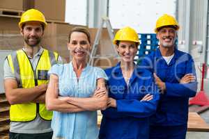 Portrait of warehouse manager and worker standing together with arms crossed