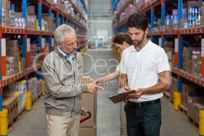 Warehouse manager and male worker interacting while working