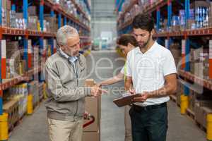 Warehouse manager and male worker interacting while working