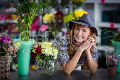 Happy female florist leaning in flower shop