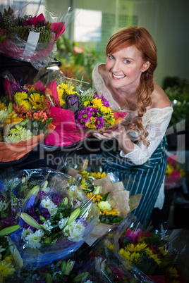 Female florist touching flower bouquet