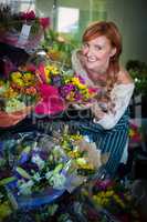 Female florist touching flower bouquet