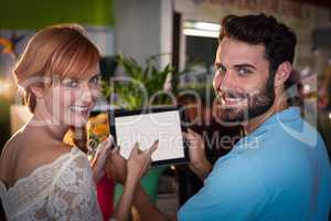 Portrait of couple using digital tablet