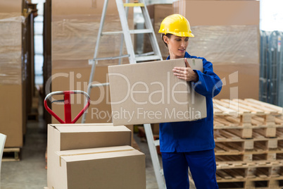 Delivery worker unloading cardboard boxes from pallet jack
