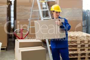 Delivery worker unloading cardboard boxes from pallet jack