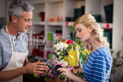 Woman making payment with her credit card to florist