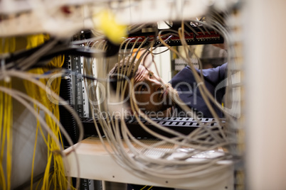 Technician checking cables in a rack mounted server