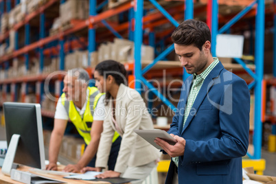 Warehouse managers and worker working together