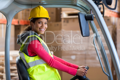 Portrait of warehouse worker using a forklift