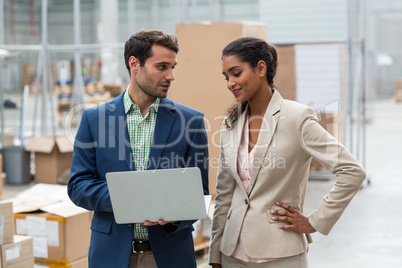 Warehouse managers discussing with the laptop