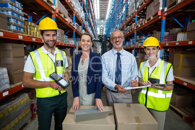 Warehouse manager and client standing with co-workers