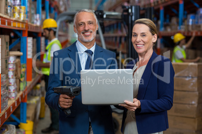 Warehouse manager and client using laptop