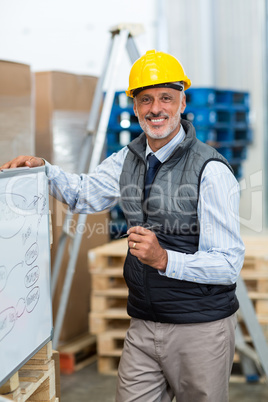 Portrait of warehouse worker standing near whiteboard