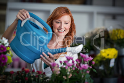 Female florist watering flowers