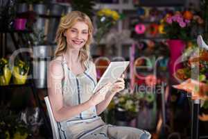 Smiling female florist using digital tablet in florist shop
