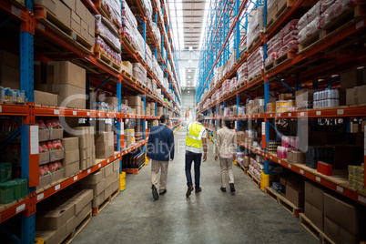 Warehouse team discussing while walking in warehouse