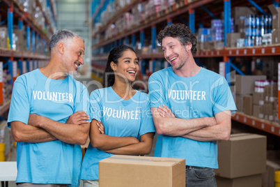 Three happy volunteers standing with arms crossed