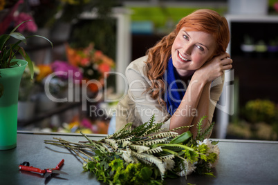 Happy female florist leaning in flower shop