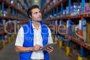 Warehouse worker holding digital tablet