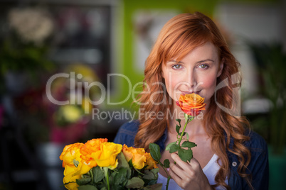 Portrait of female florist holding bunch of flowers