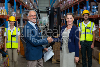 Portrait of warehouse manager shaking hands with client