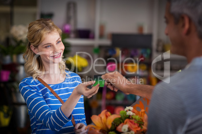 Woman making payment with her credit card to florist