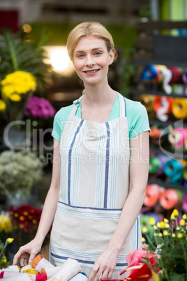 Happy female florist standing in flower shop