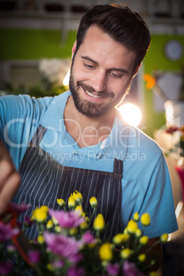 Male florist preparing flower bouquet