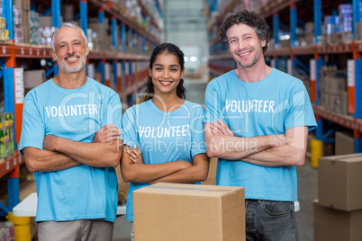 Portrait of three happy volunteers standing with arms crossed Portrait of three happy volunteers standing with arms crossed