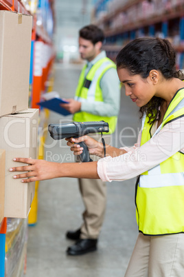Female warehouse worker scanning box