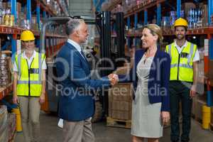 Warehouse manager shaking hands with client